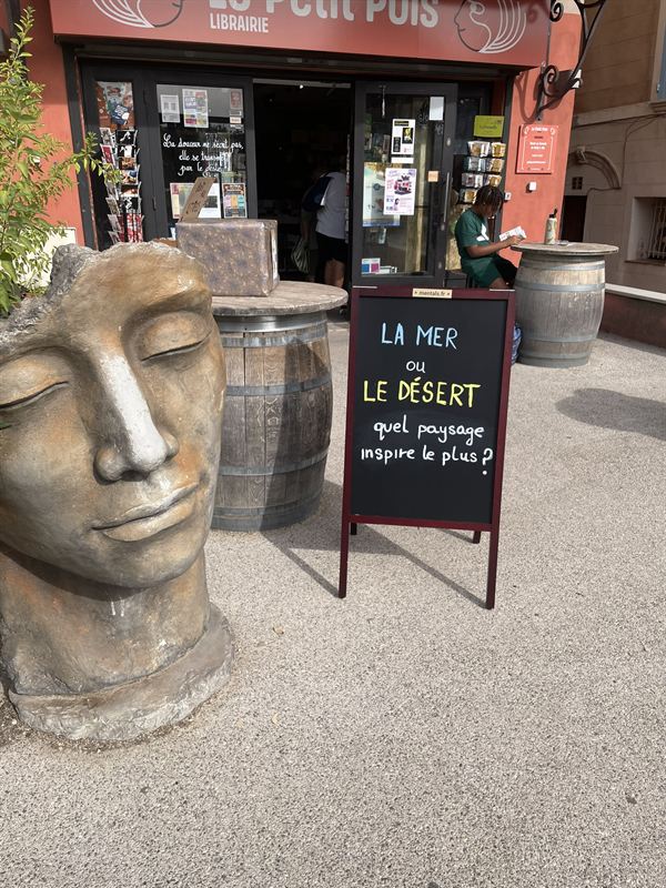 Ardoise Mentals devant une librairie : « La mer ou le désert, quel paysage inspire le plus ? »